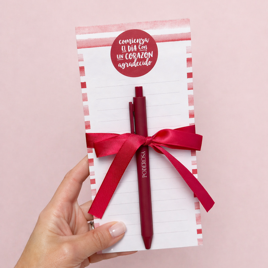 Red pen in a gift box with a red ribbon on a pink background